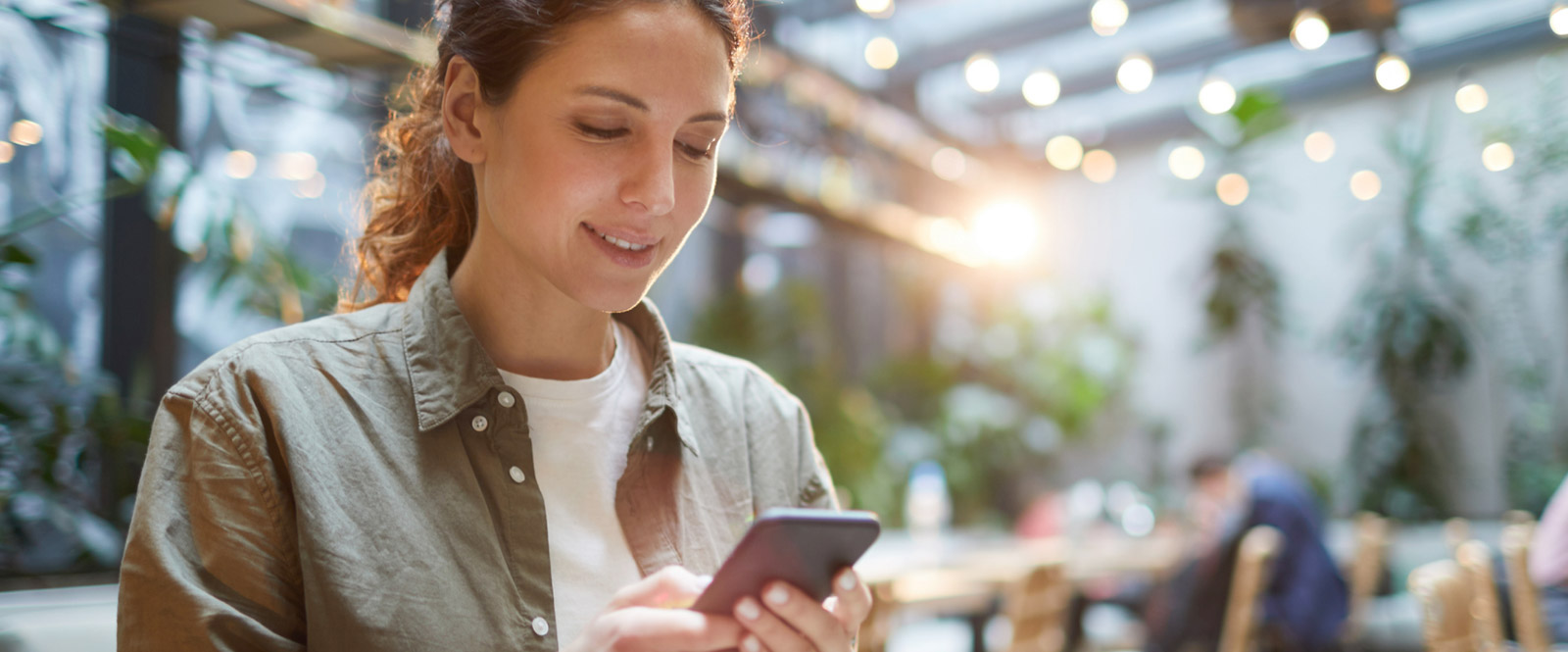 Woman using smartphone in restaurant