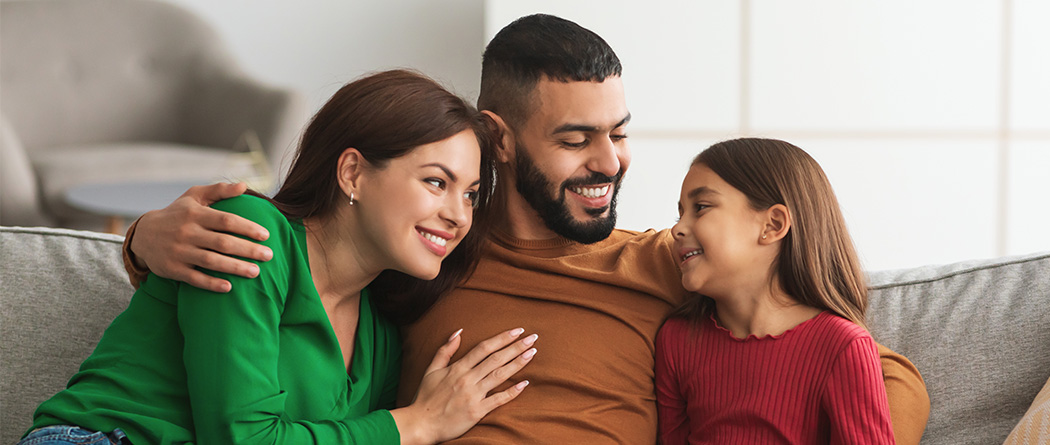 Young family playing guitar in living room